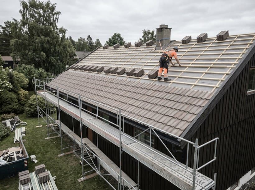 Illustrasjon av takarbeid på en villa med takstein og stillas